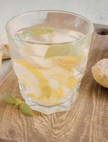 Copo de água aromatizada com limão e hortelã fresca em fundo claro