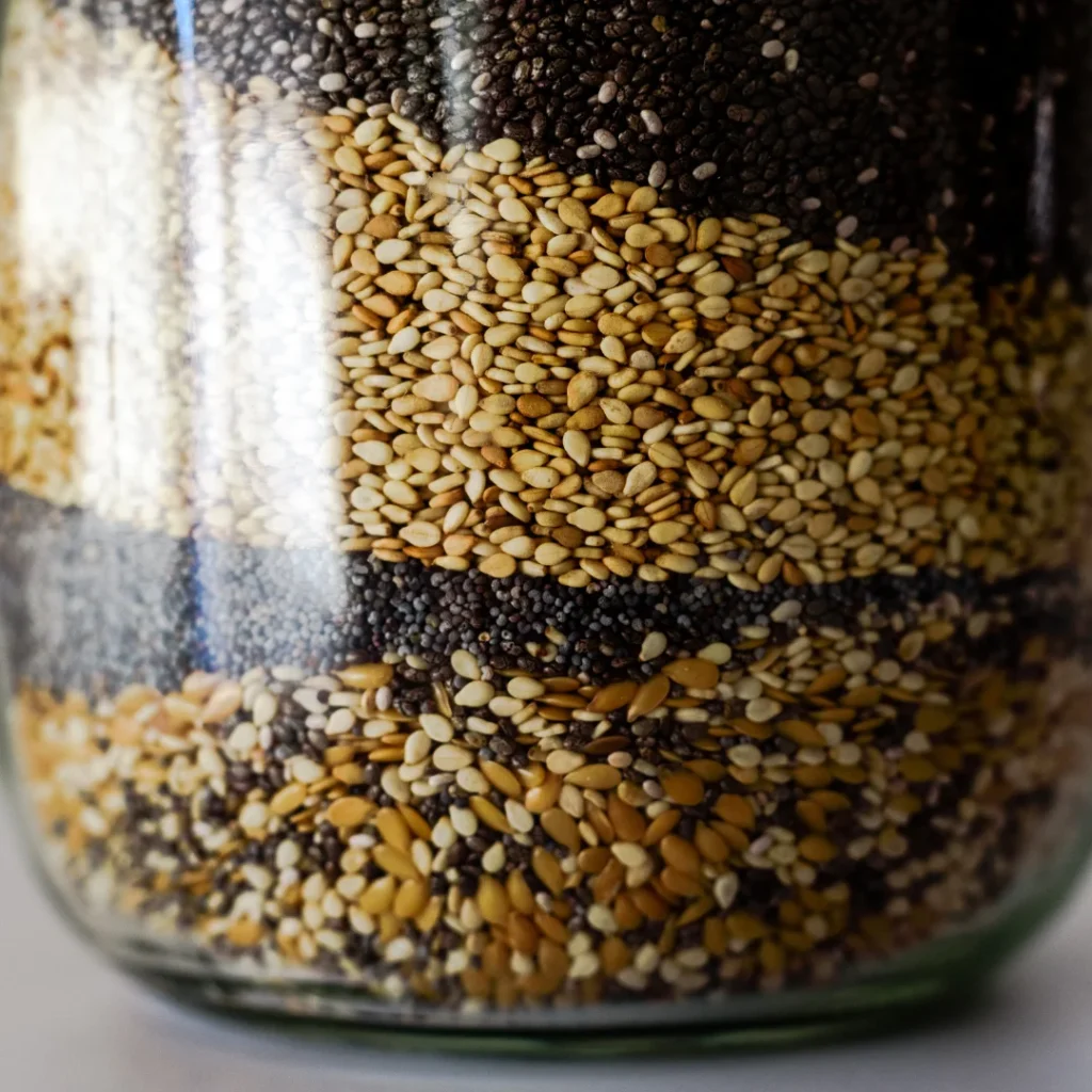 Pote de vidro contendo sementes de chia e linhaça, ingredientes ricos em fibras e ômega-3.